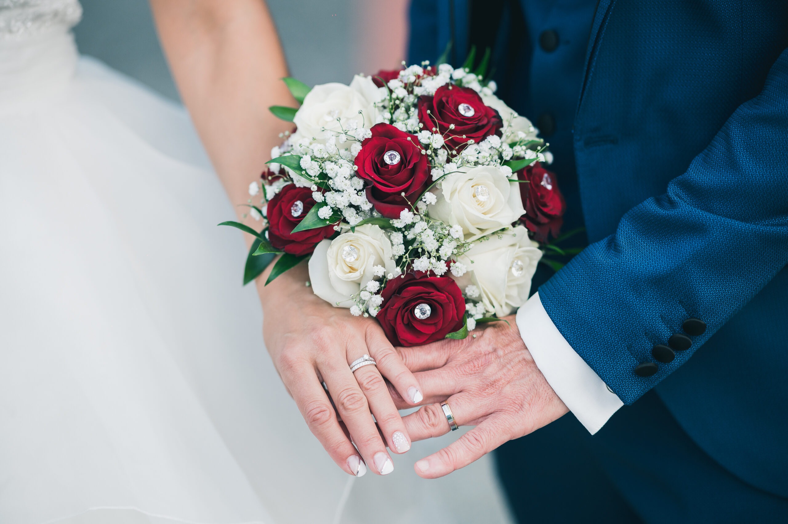 Bouquet de la mariée avec des roses rouges et blanches pour son mariage.